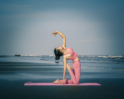 Person doing yoga or stretching outdoors enjoying a serene environment